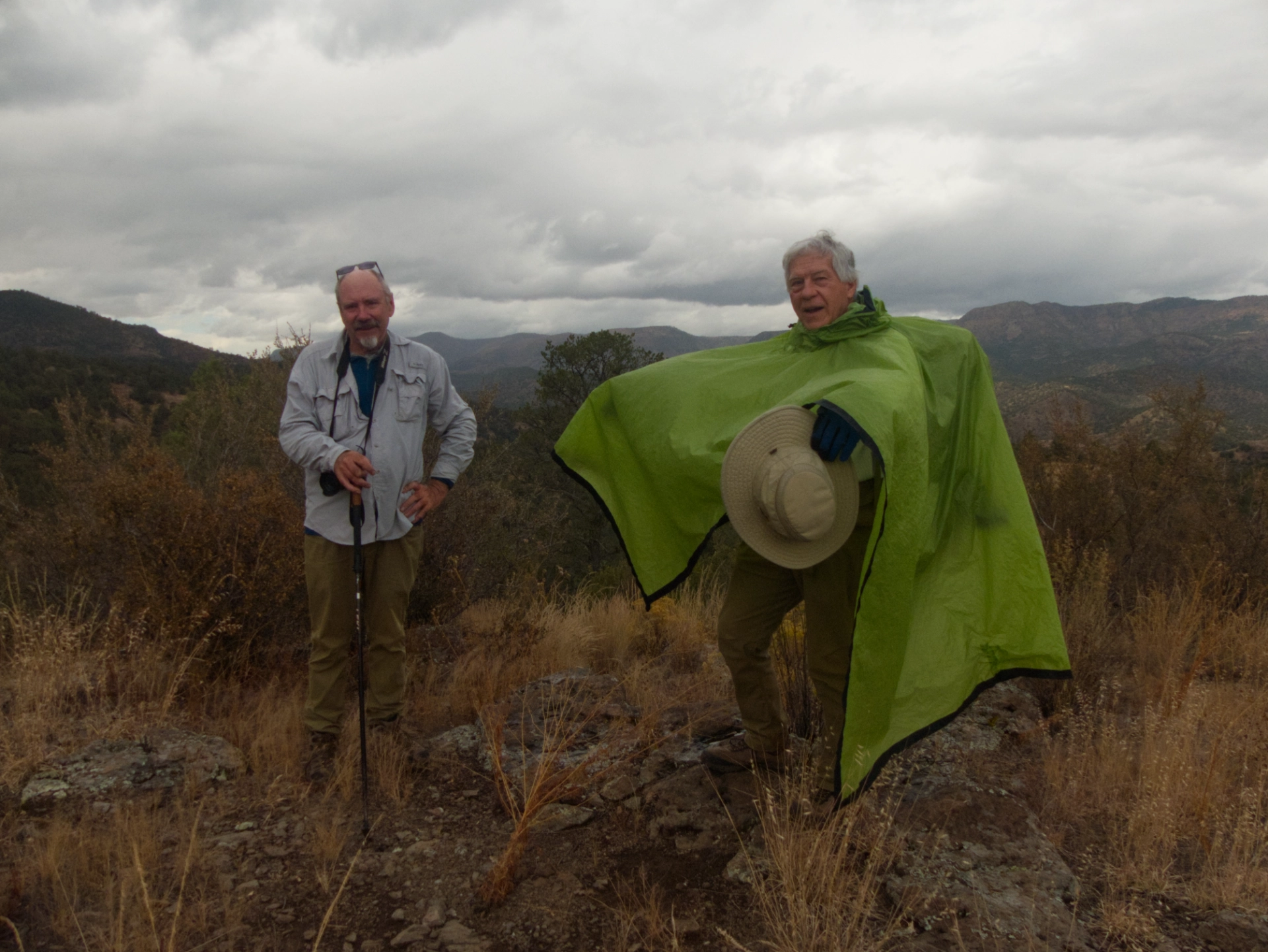 hikers on a knoll with dark clouds