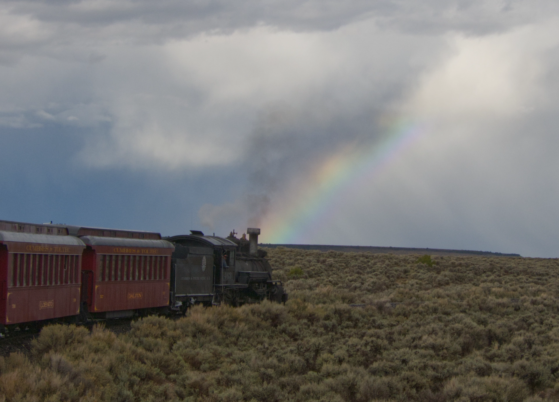 steam engine chugging toward a rainbow