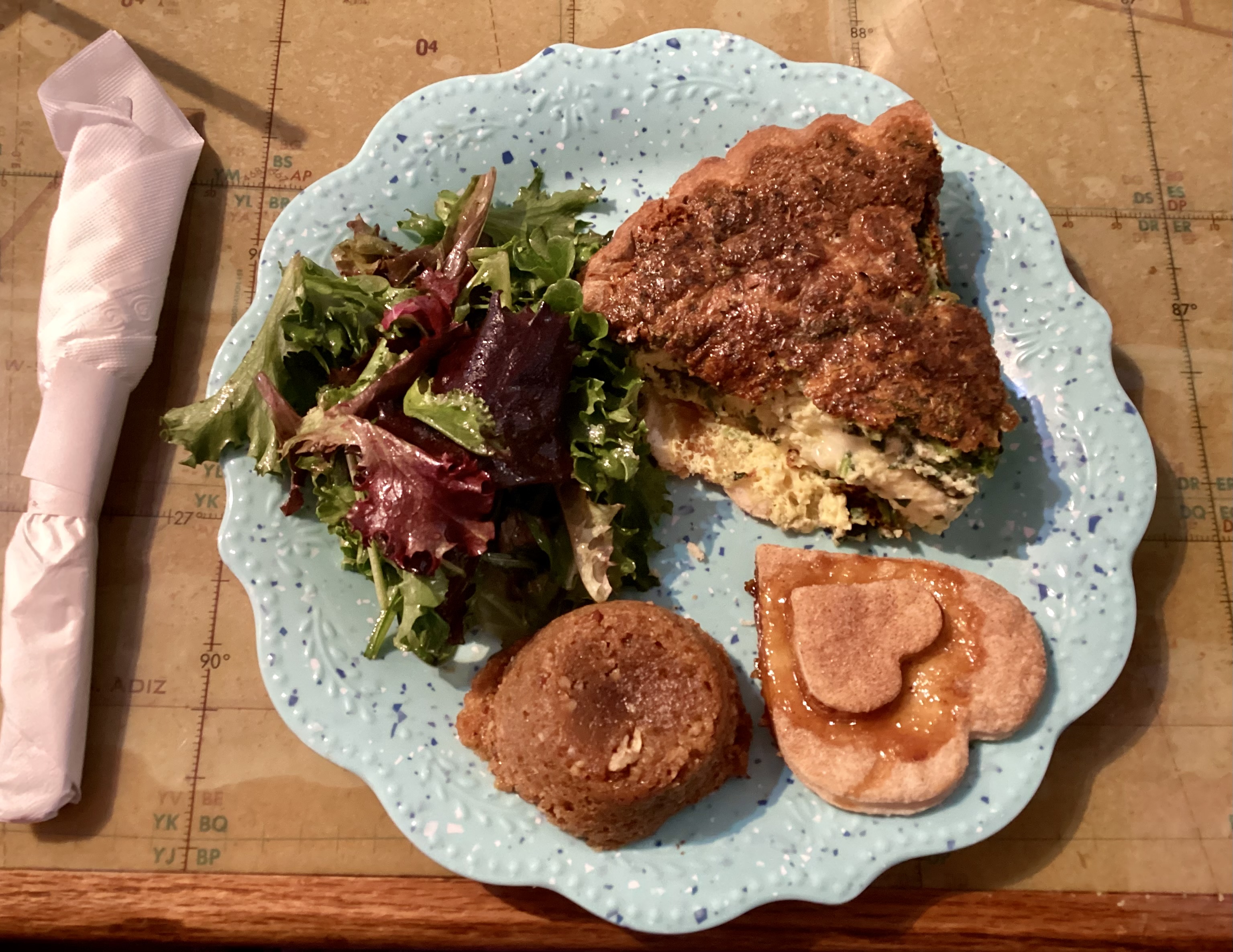 huge chunk of quiche with salad and a pecan bran muffin