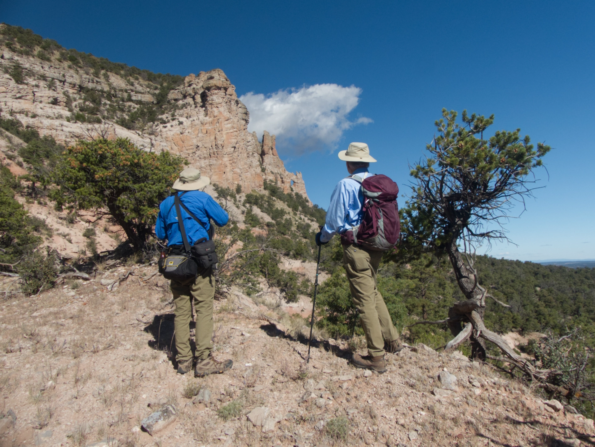 hikers looking toward a rock window