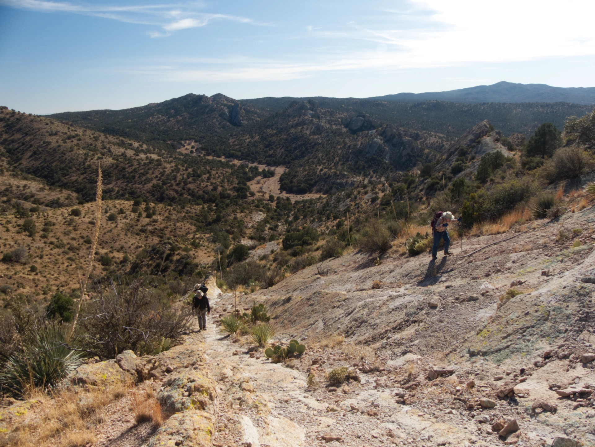 hikers making their way along a bare rock slope