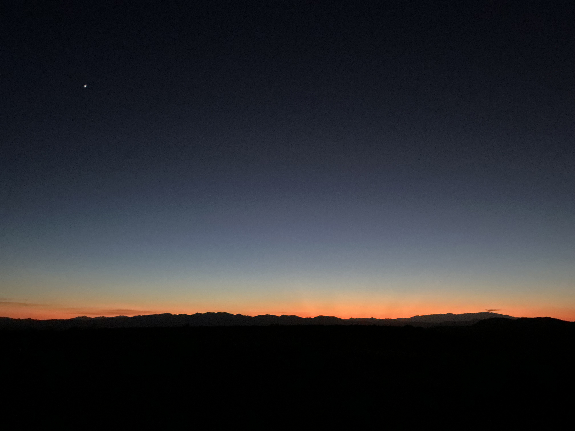 silhouettes of mountains in fading light