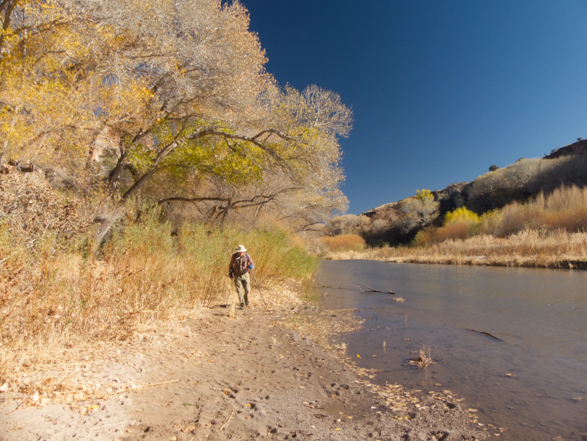 Dennis walking along the shore of the Gila River