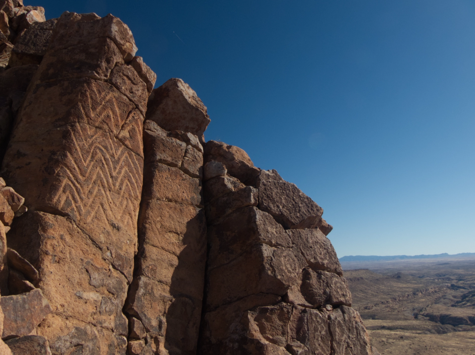 glyphs on cliff with view of the river valley